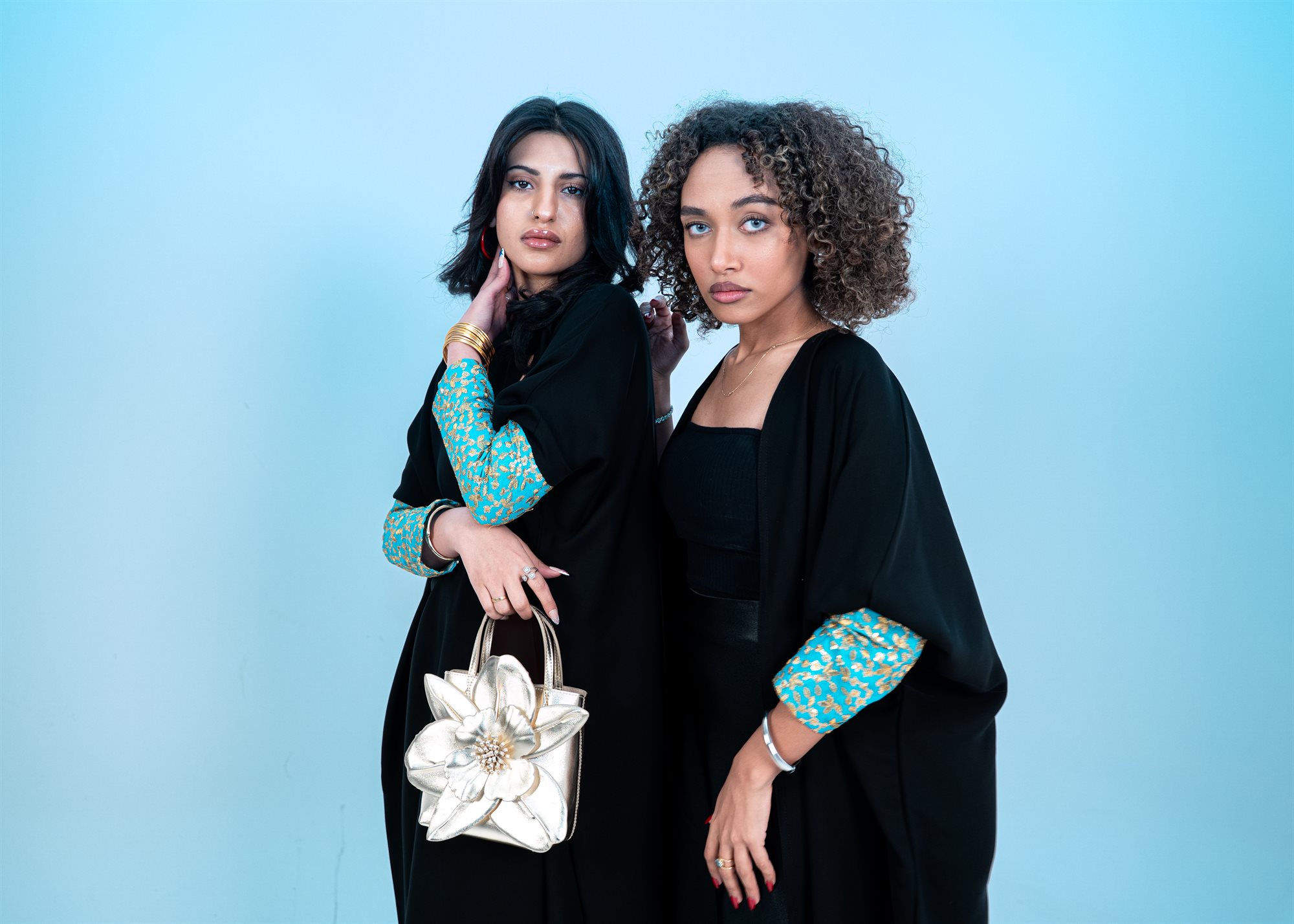 Cleff Boutique, both models standing with the gold flower bag