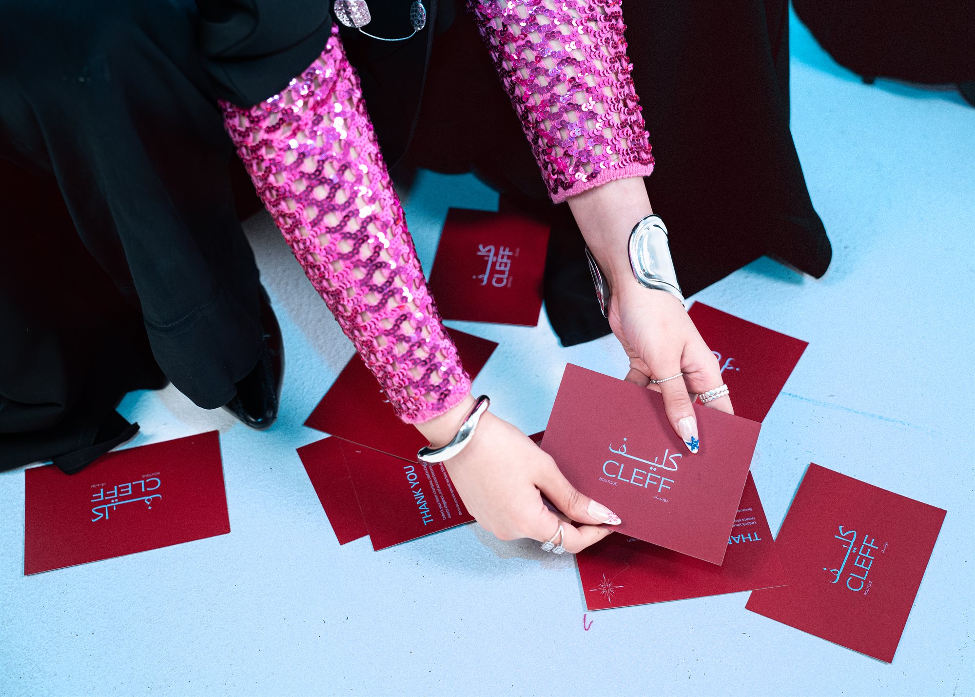 Cleff Boutique, hands arranging brand cards on the floor