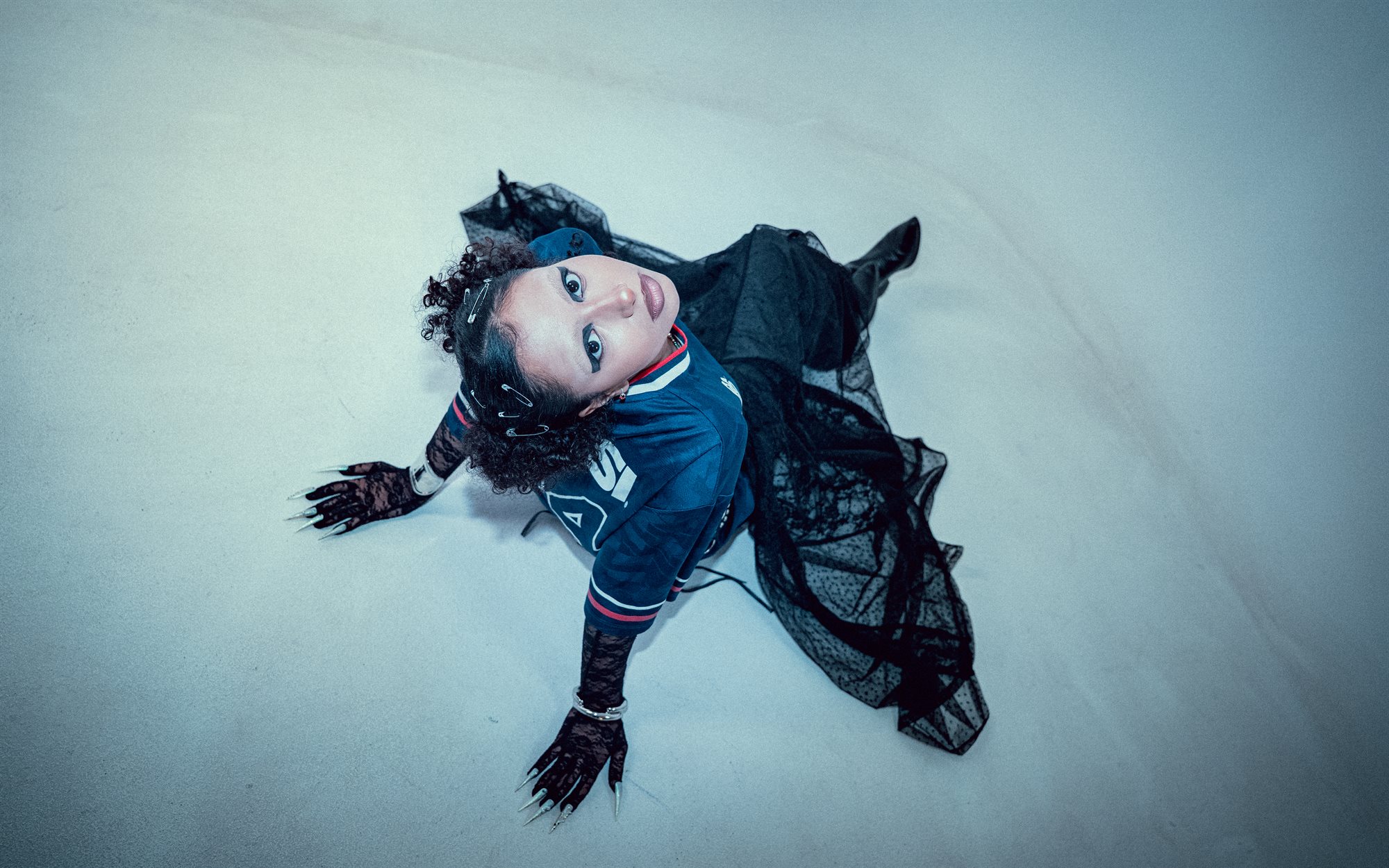 Eyeconic, lying down with fishnet drape