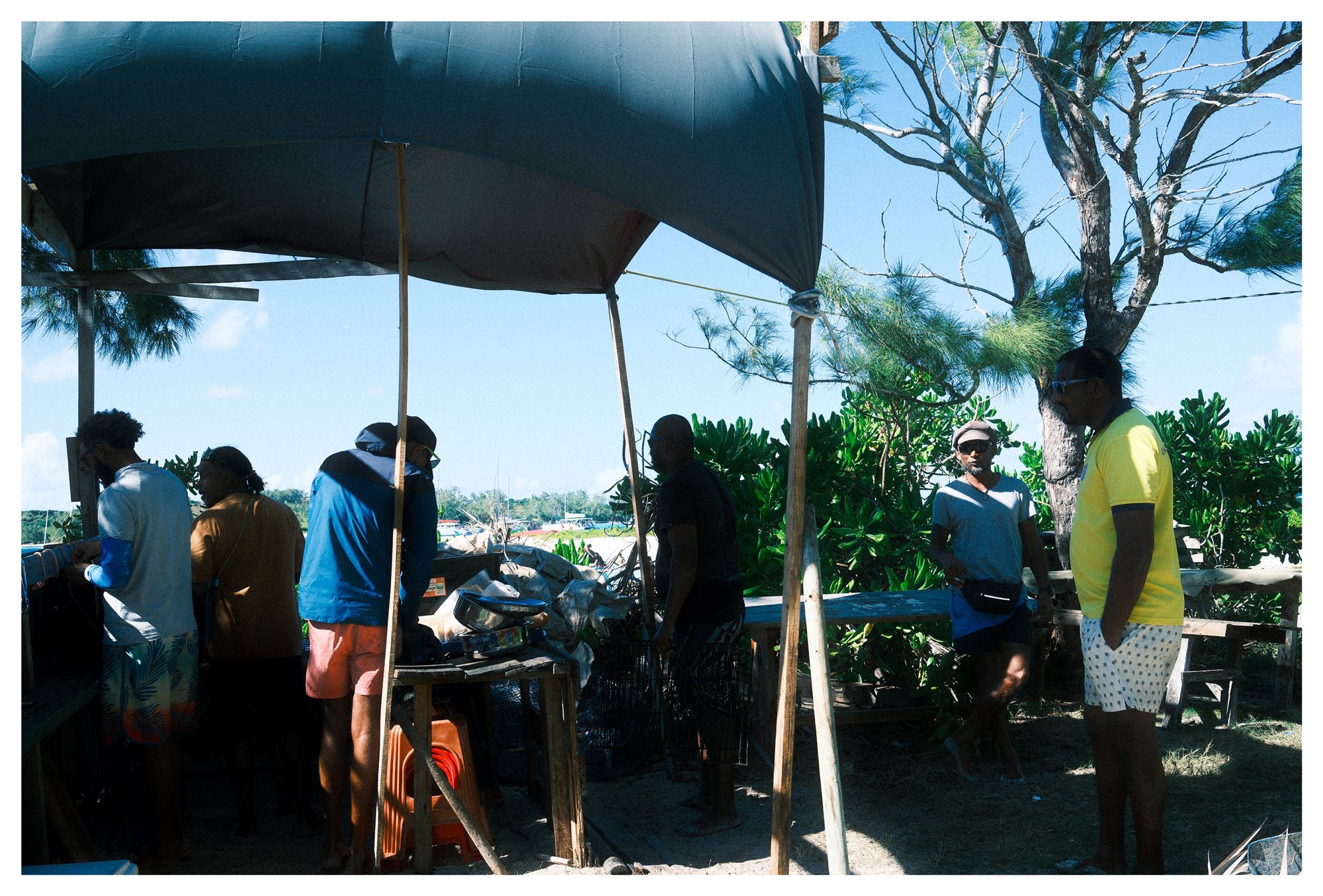 Mauritius, a small gathering of men beside a beach market