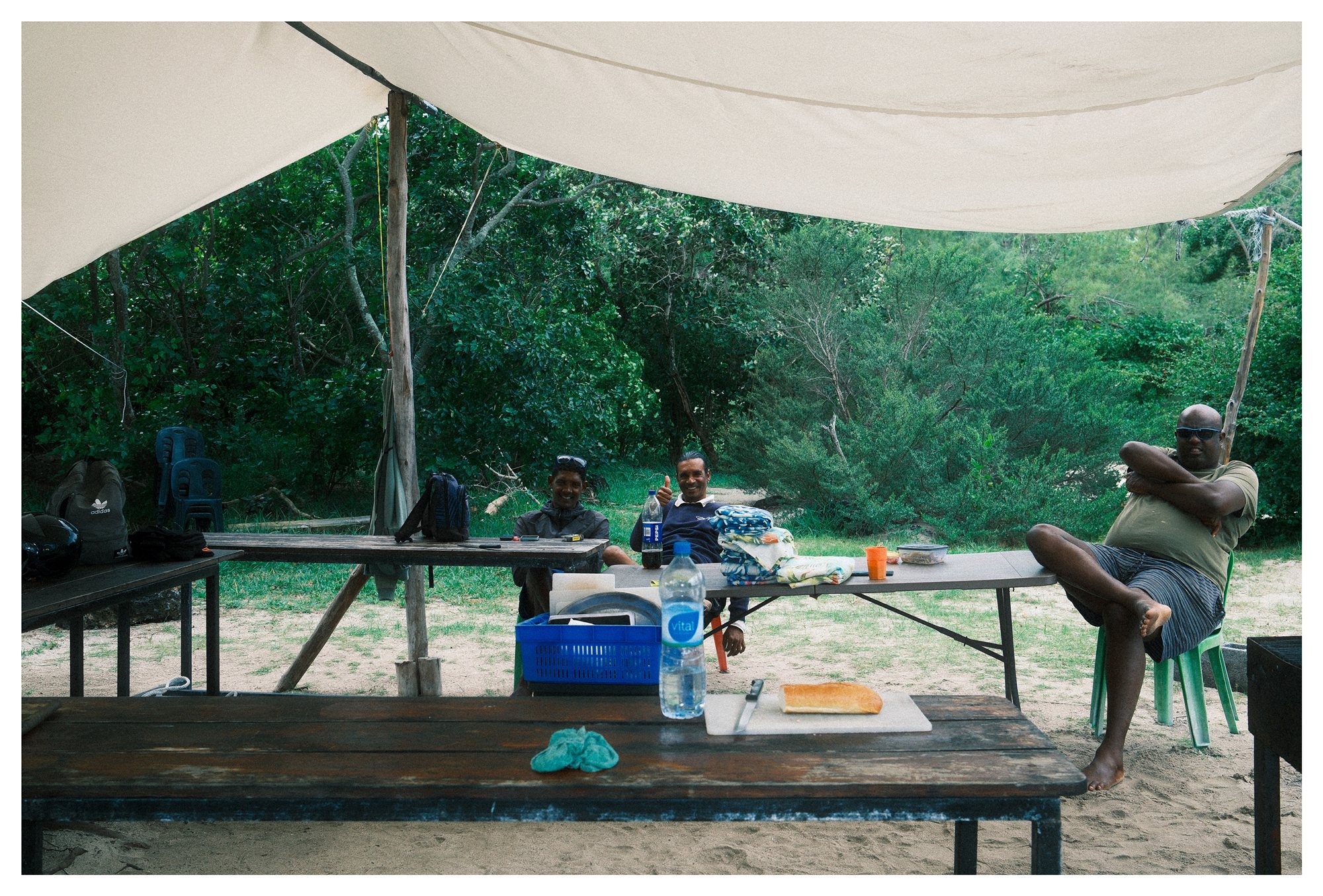 Mauritius, three men sharing a meal under a tent