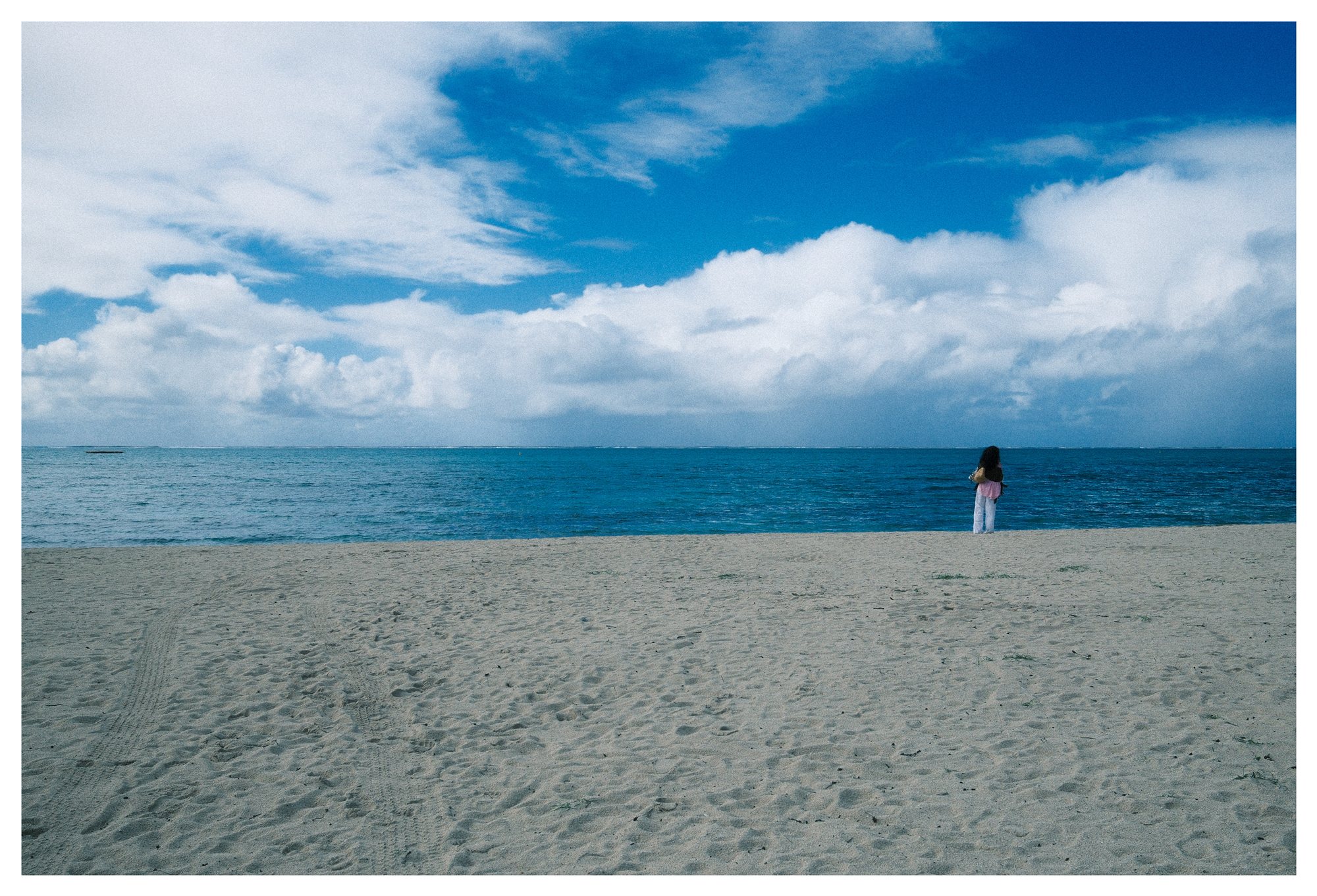 Mauritius, a lone figure at the edge of the sea beneath open sky