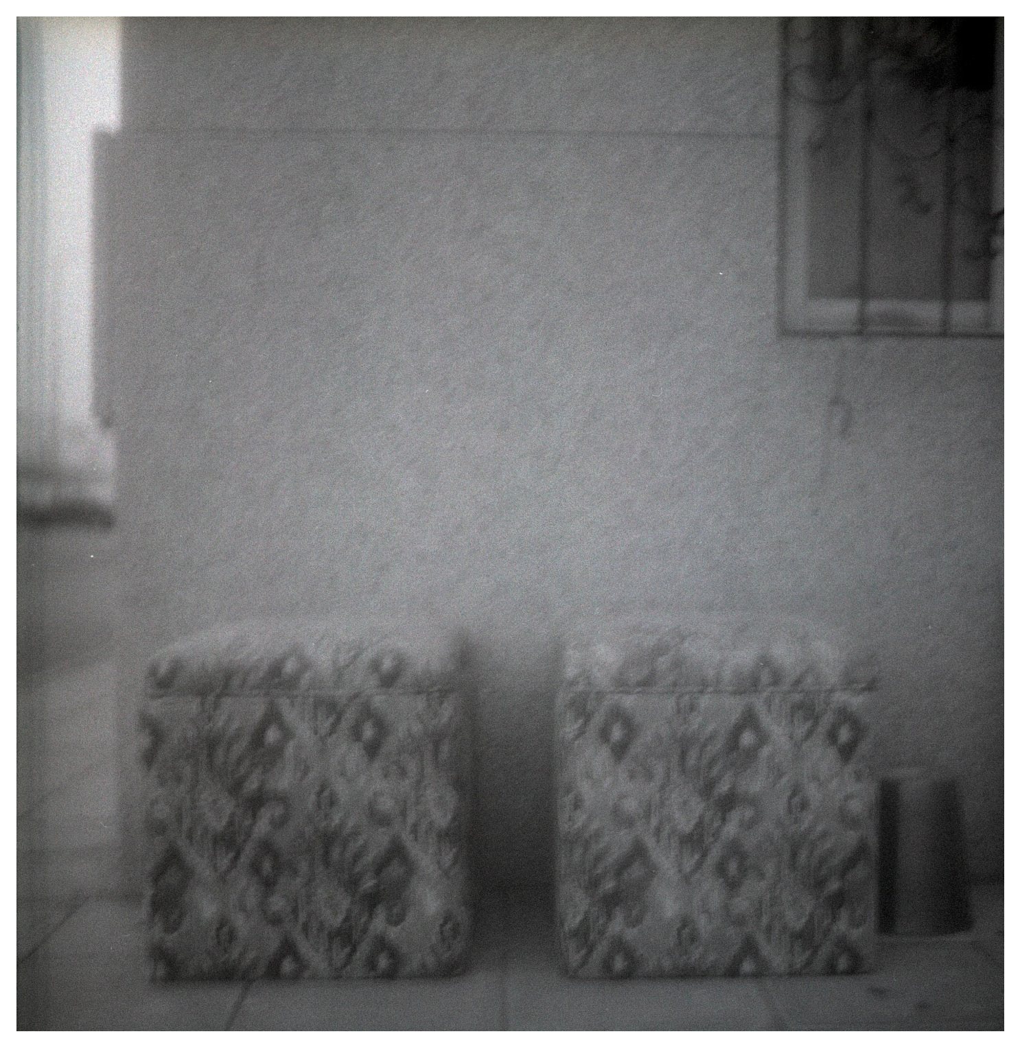 Pieces of a Familiar Place, two patterned cushions against a quiet wall